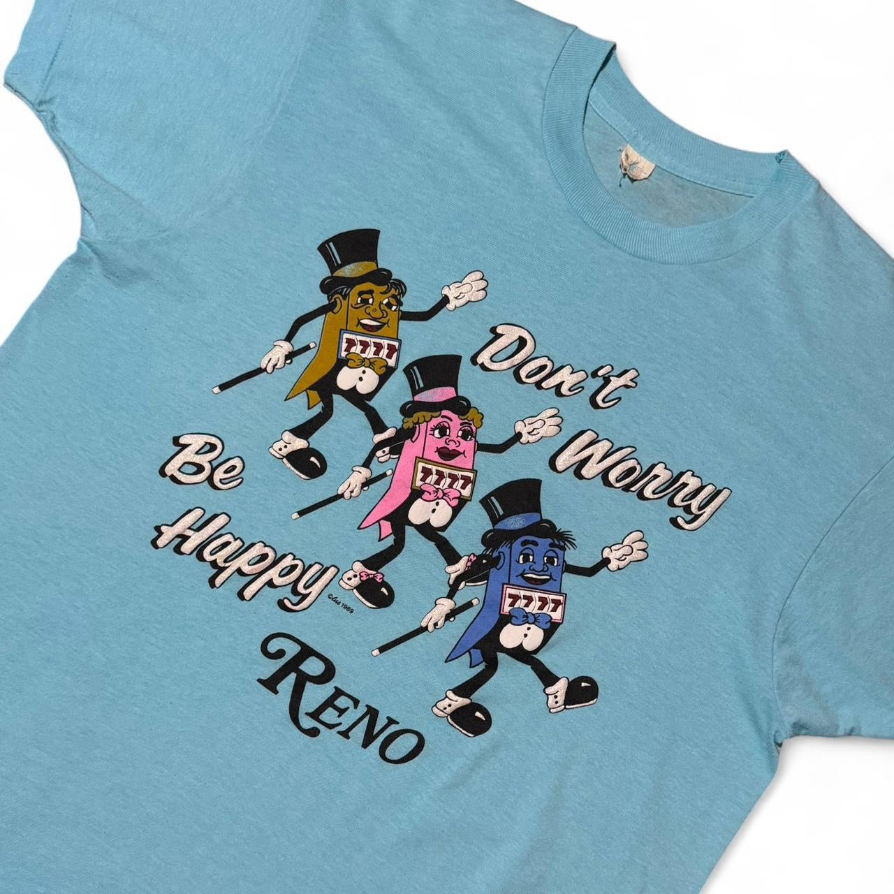 1989 Baby Blue Reno Nevada Don’t Worry, Be Happy Gambling Slots Machine Souvenir Tee
